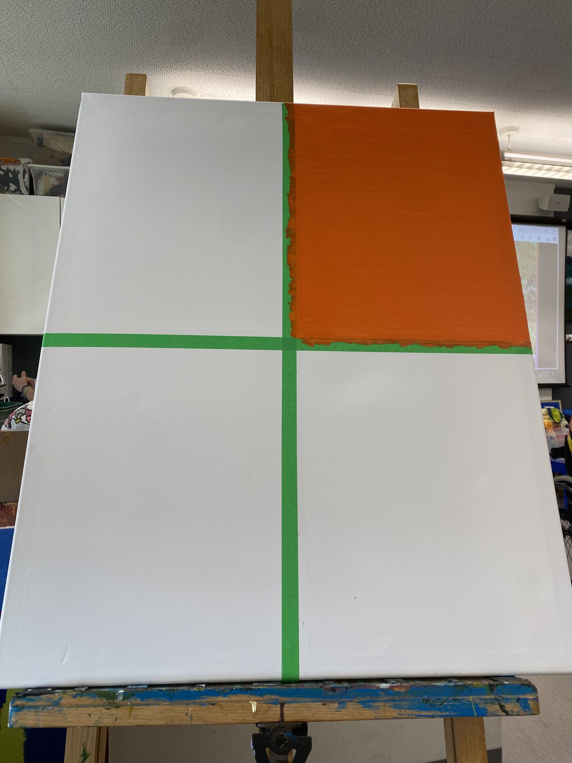 A large canvas divided into 4 oblong sections divided by a thick green line. The top right section is painted a rich burnt orange.