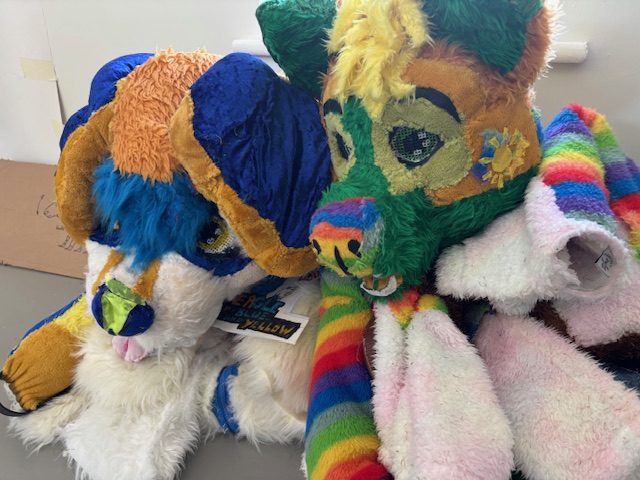 Costumes of Spectrum Wolf and Beagle in Blue and Yellow sit lifeless on the floor at PAW studios ready to work with