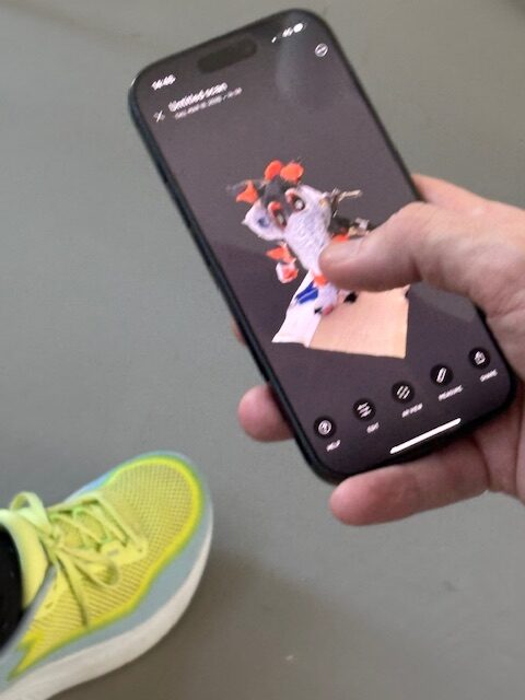 an iphone with an animation demo of Lucy's characterand we see Lucy's yellow shoe alongside
