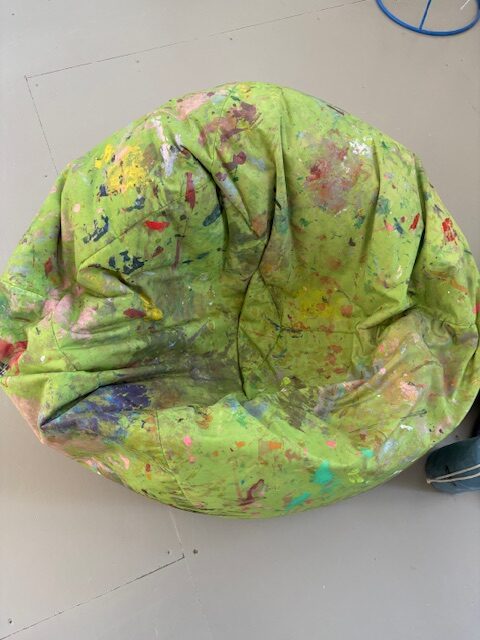 Lucy's green bean bag covered in paint daubs - a relaxing place for her