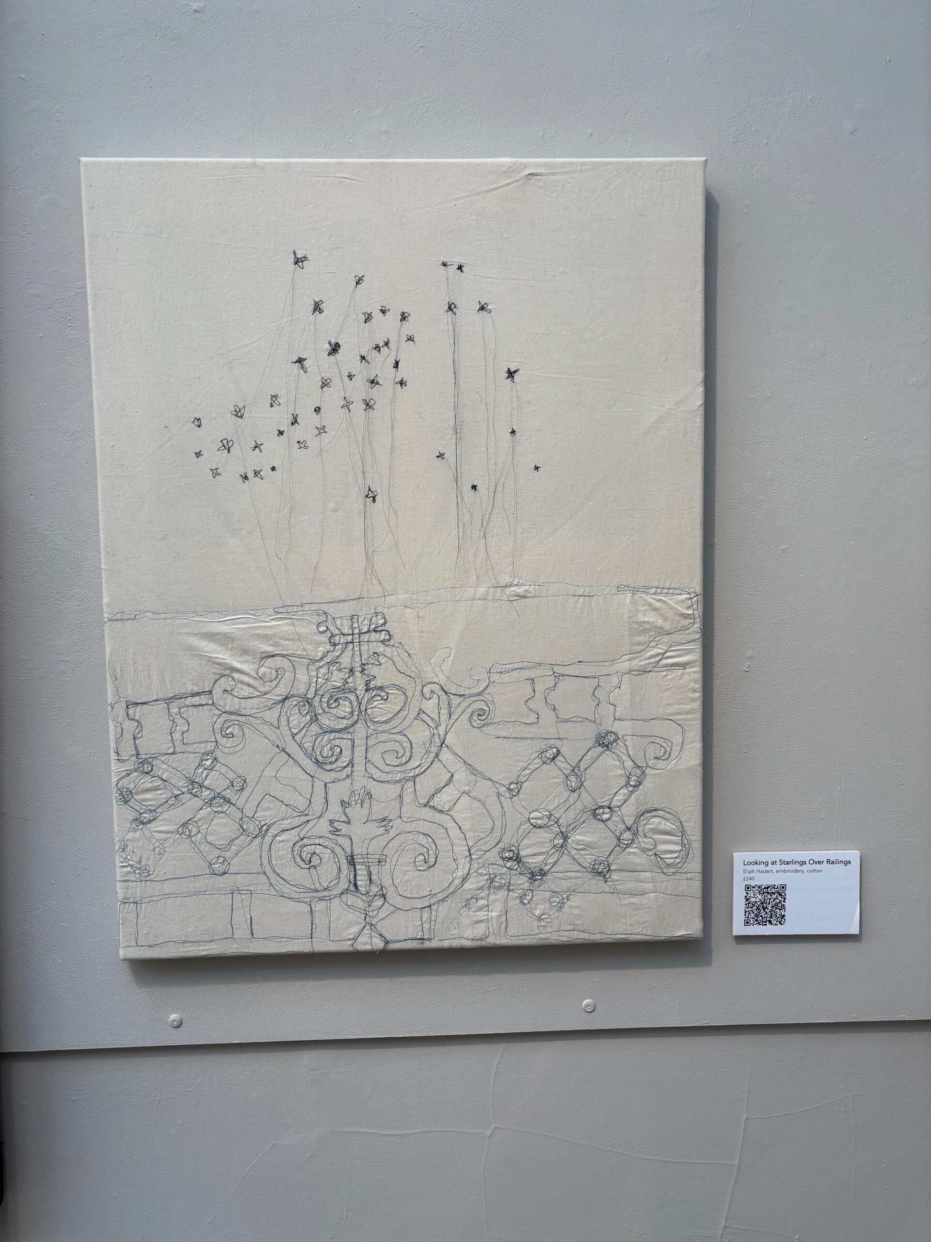 A picture of Eliph's work at Worthing Museum we see the canvas with deicate stirching showing starlings leaping up wards from the shore in a cream coloured canvas