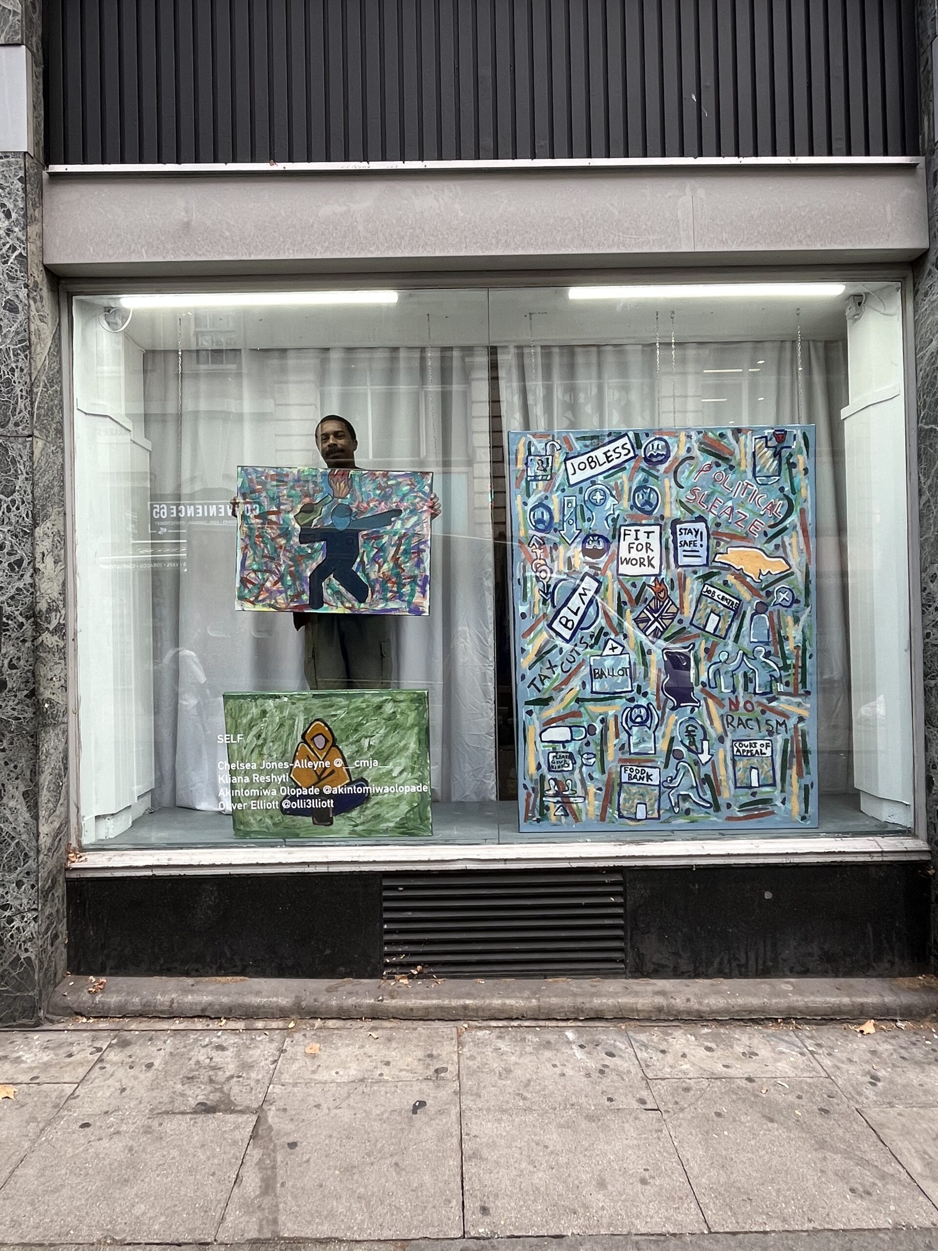 Thompson inside the window in Holborn installing his work