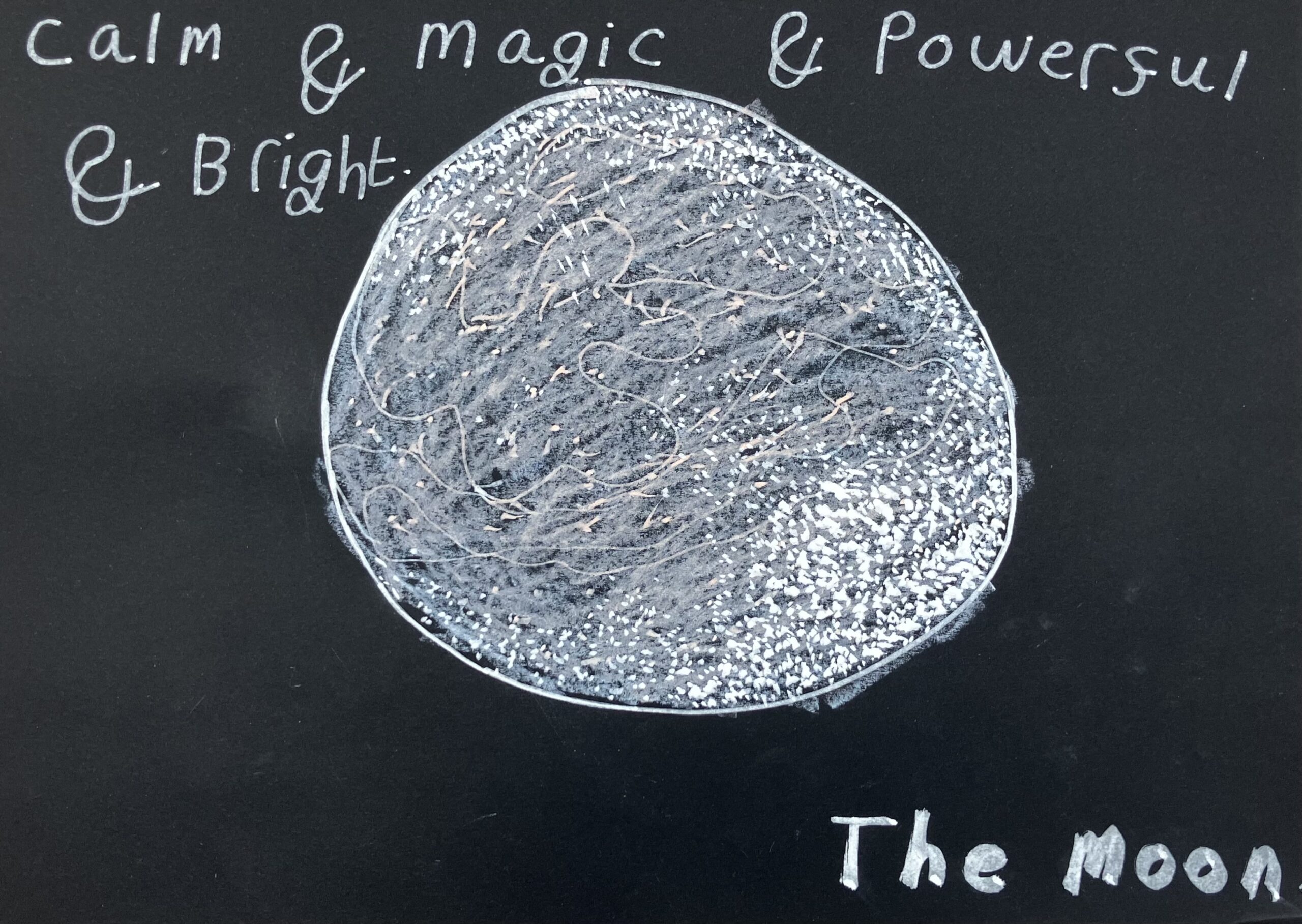 This is a piece of work I made using chalk pens and oil pastels on black card. It is a drawing of a white moon in the middle of the black paper with the words ' Calm and Magic and Powerful and Bright. The Moon' written around the moon.