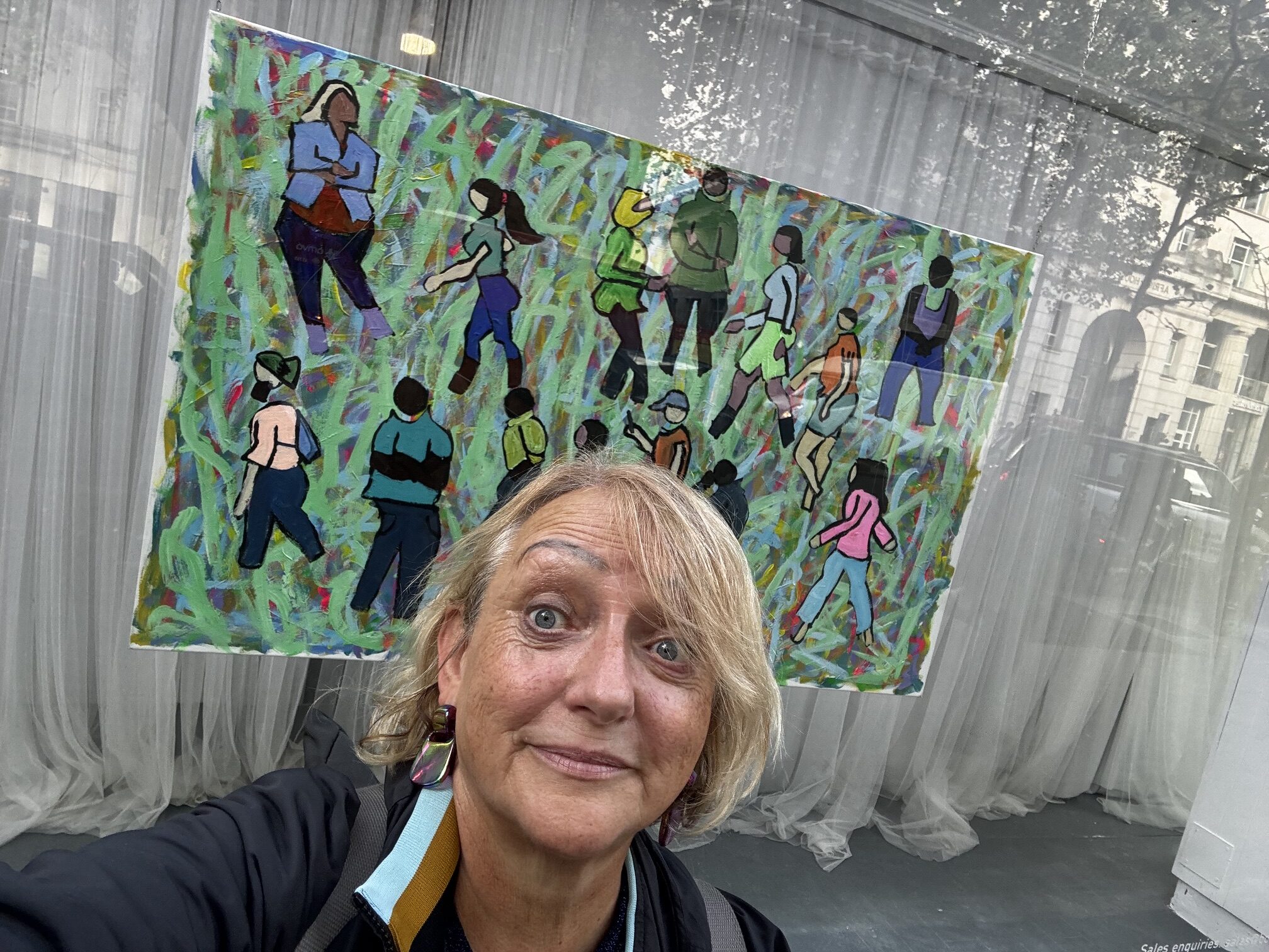Sarah outside the window in Holborn with Thompson Hall's vibrant artwork behind her